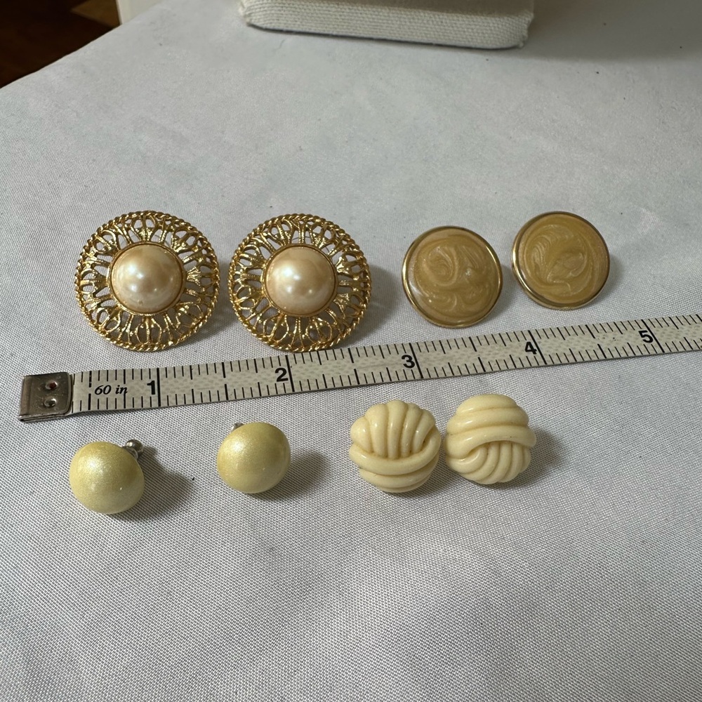 Four pair of beige and gold vibe earrings